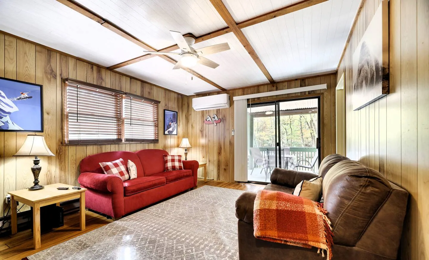 Lower family room with red pullout sofa and sliders to the porch at RedHawk Chalet