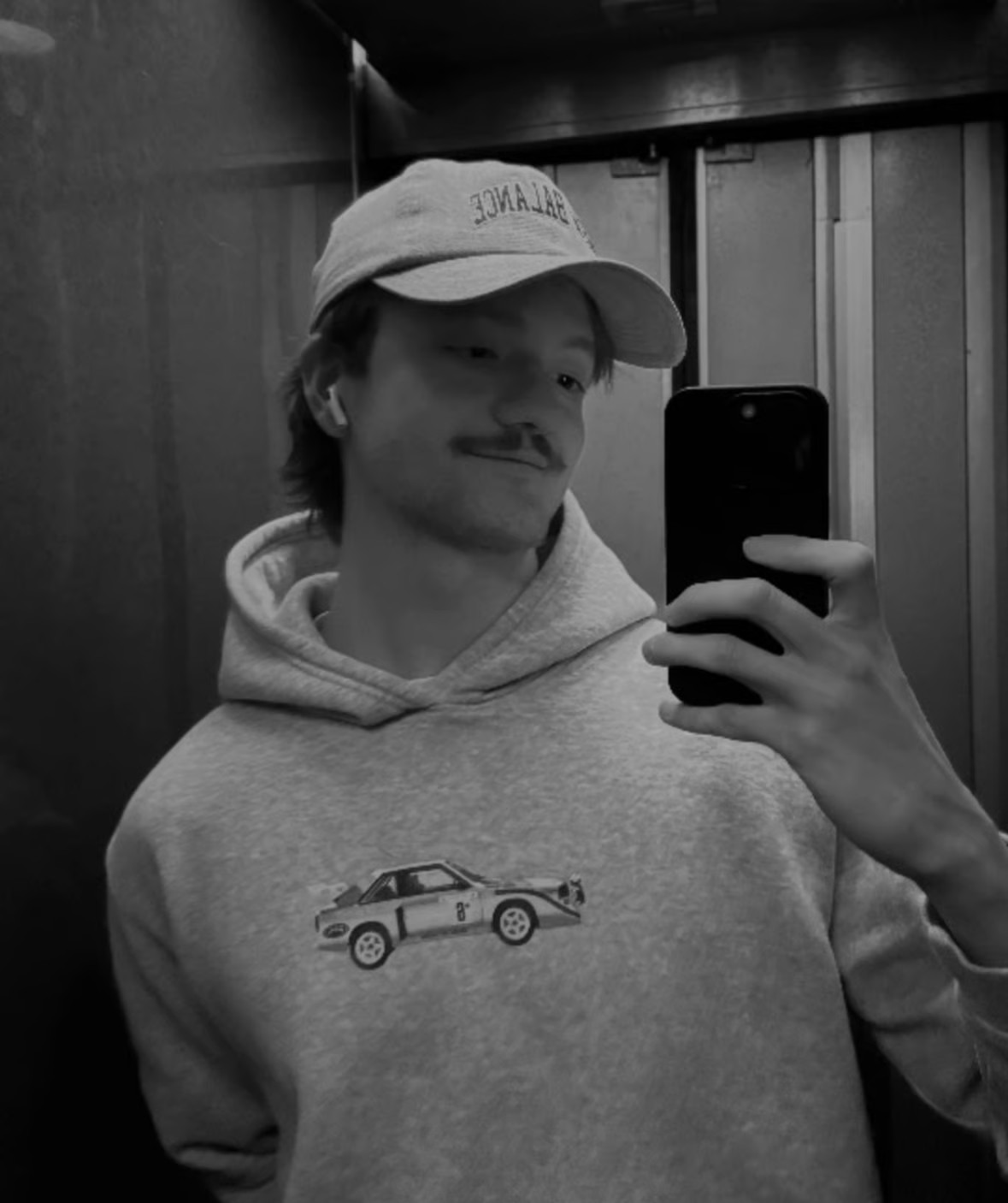 Three individuals gathered around a table, engaged in discussion while examining a laptop.