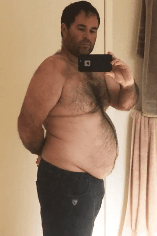 A man stading with Surfboard