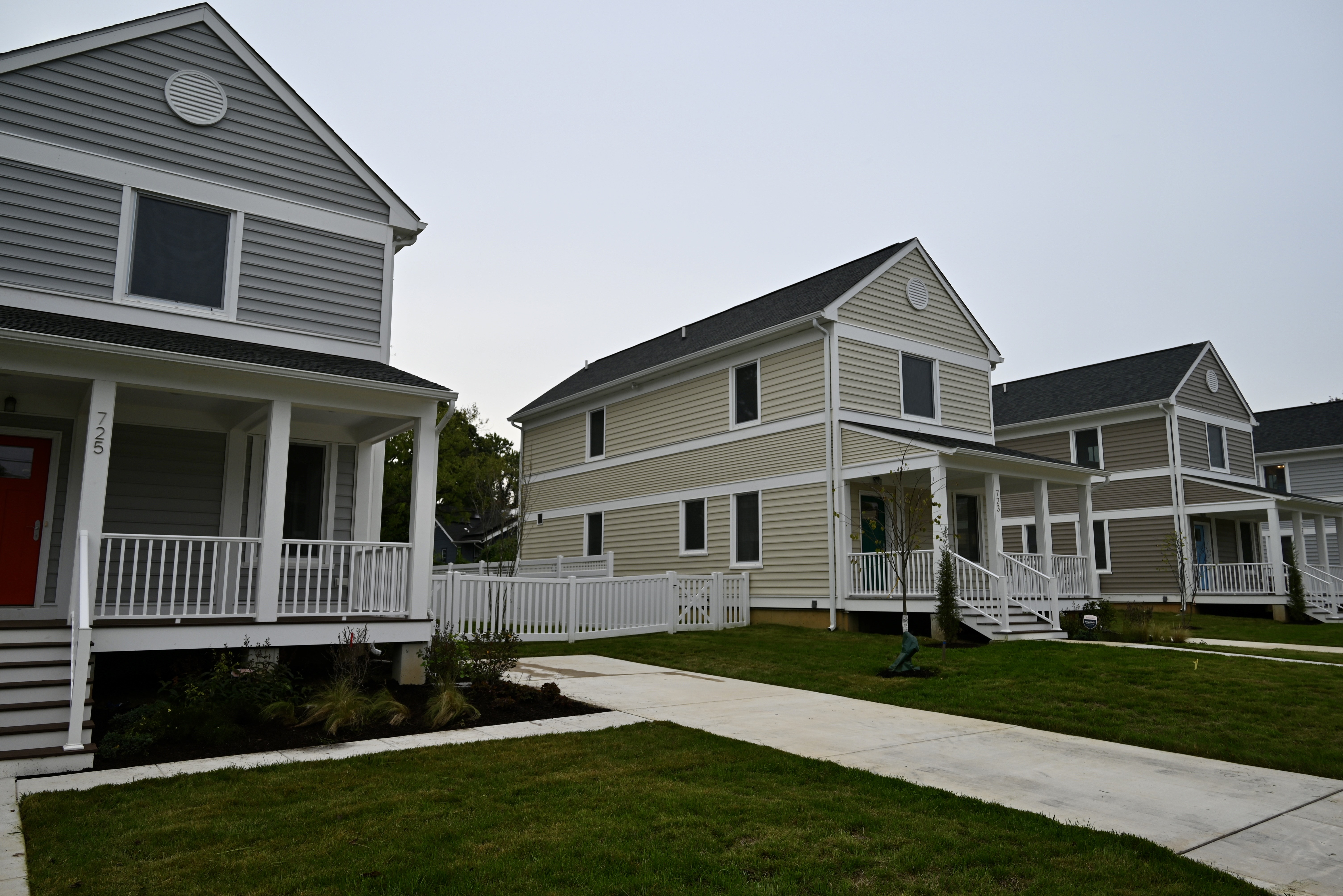 man in gray hoodie and blue denim jeans standing on brown wooden parquet flooring