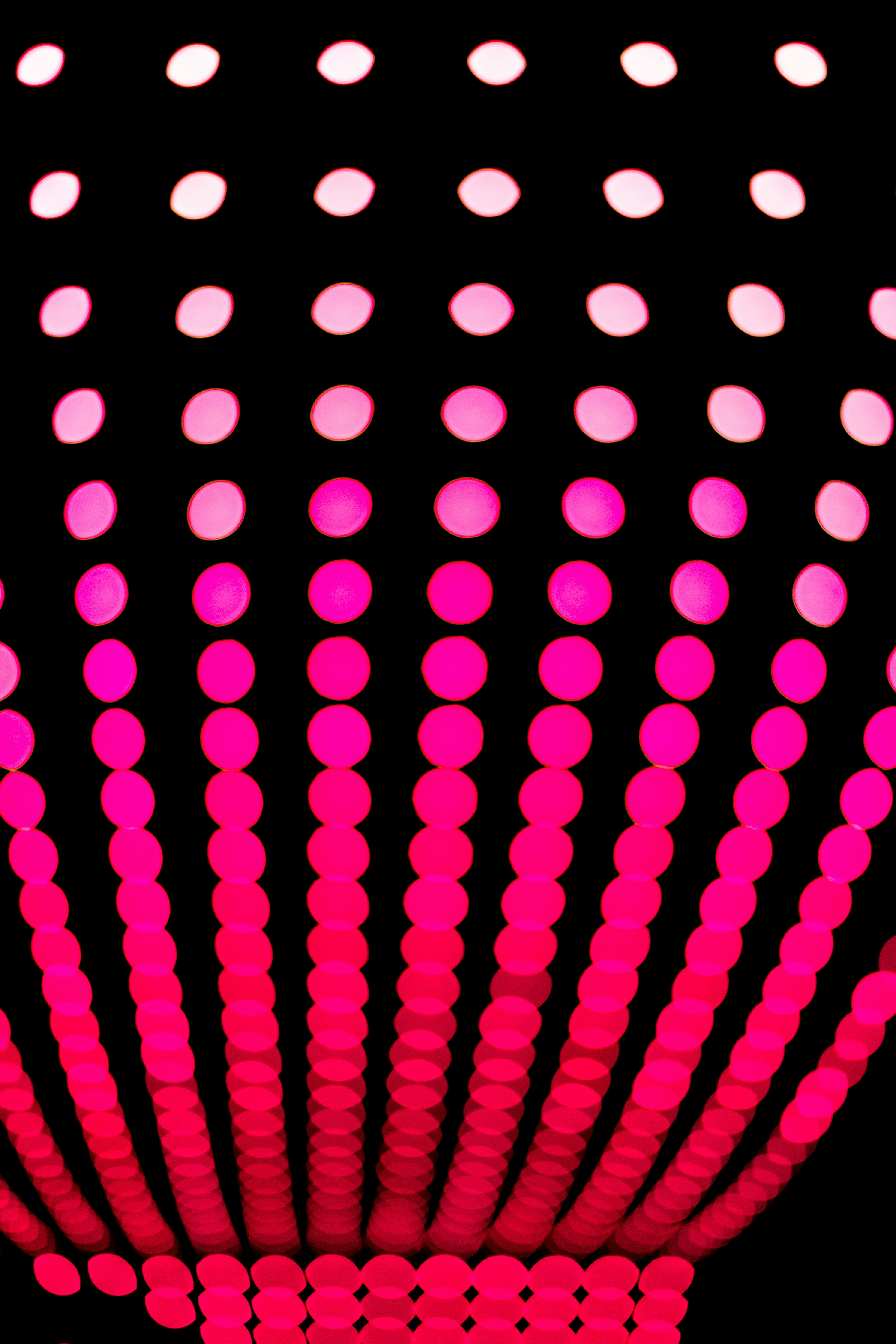 a black background with pink and white circles