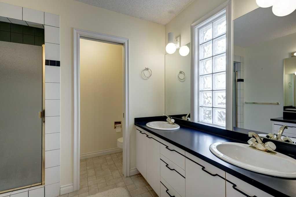 Strathcona ensuite before: black laminate double vanity and glass block window