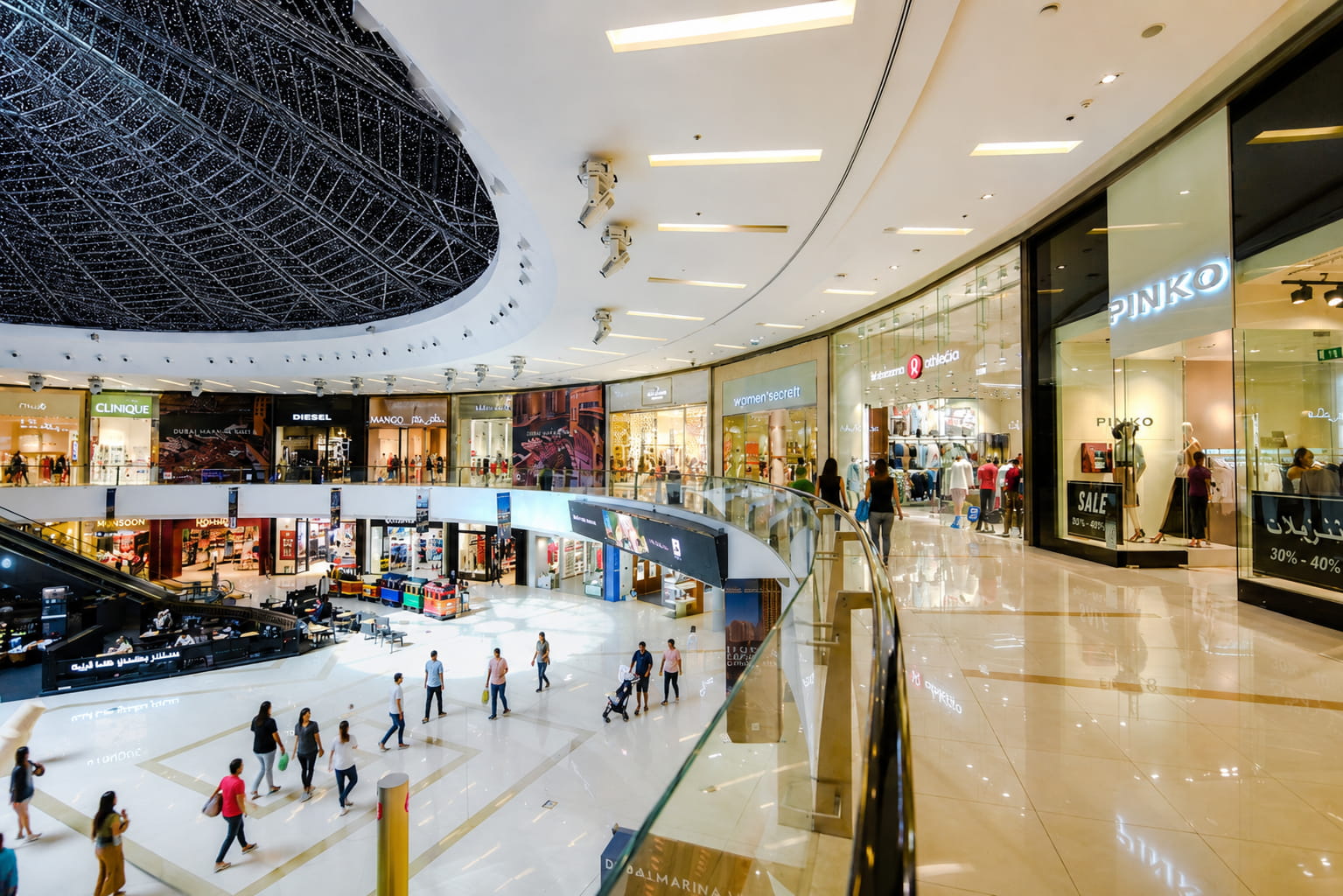 Interior view of Dubai Marina Mall featuring premium retail stores, open atrium spaces, and direct lifestyle amenities accessible from Marina Plaza. 
