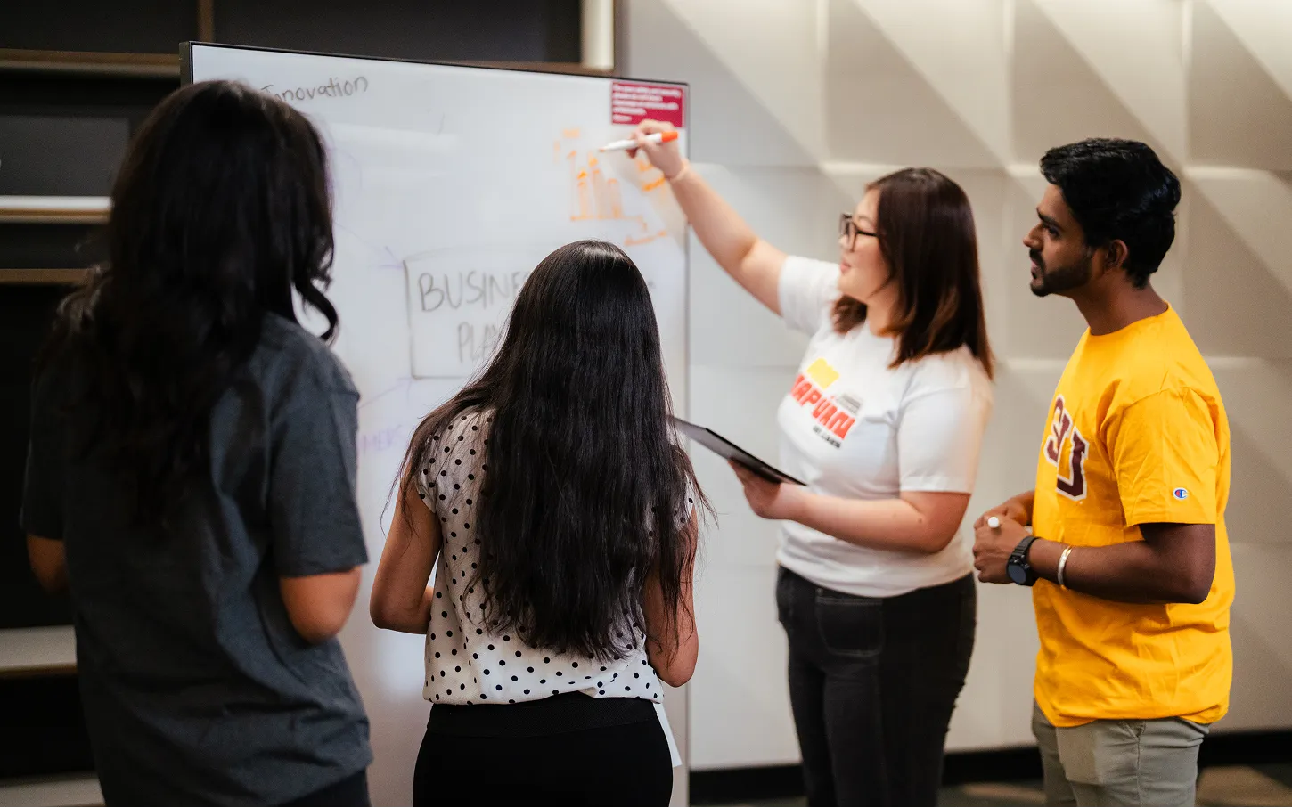 Students working through ideas together at a whiteboard at Arizona State University