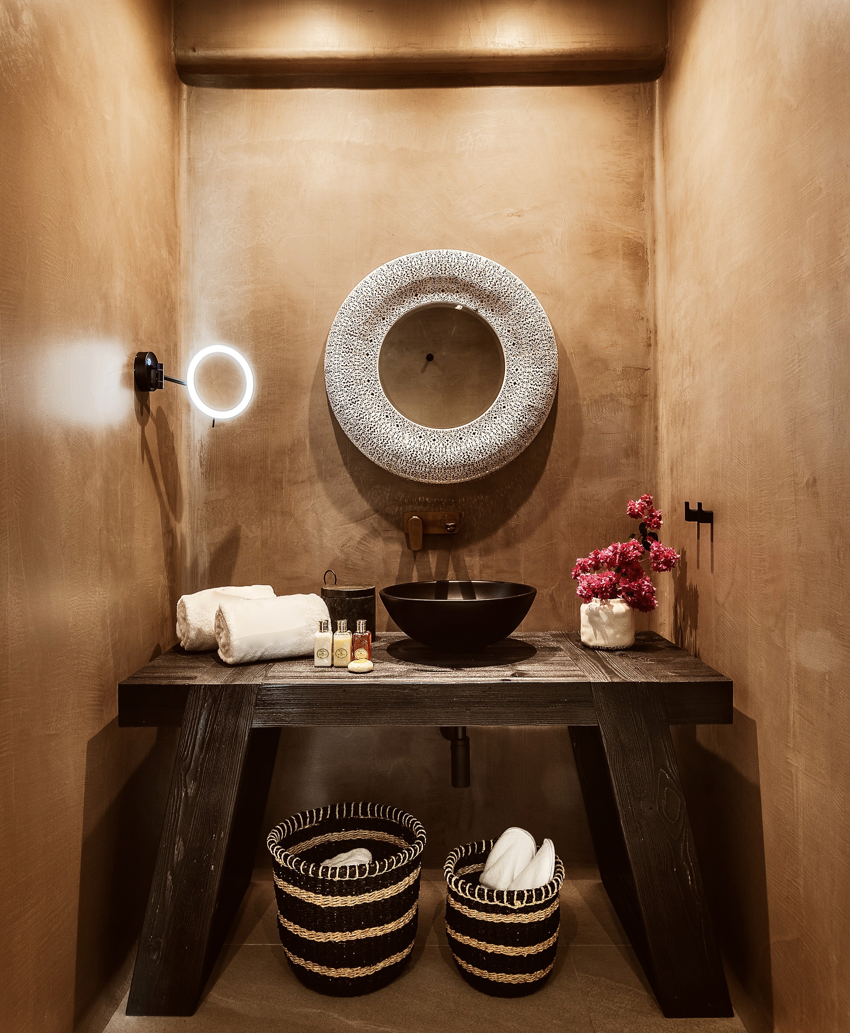 Moroccan Sculptural hotel bathroom featuring raw stone basins and high-light architectural glazing by topos design studio