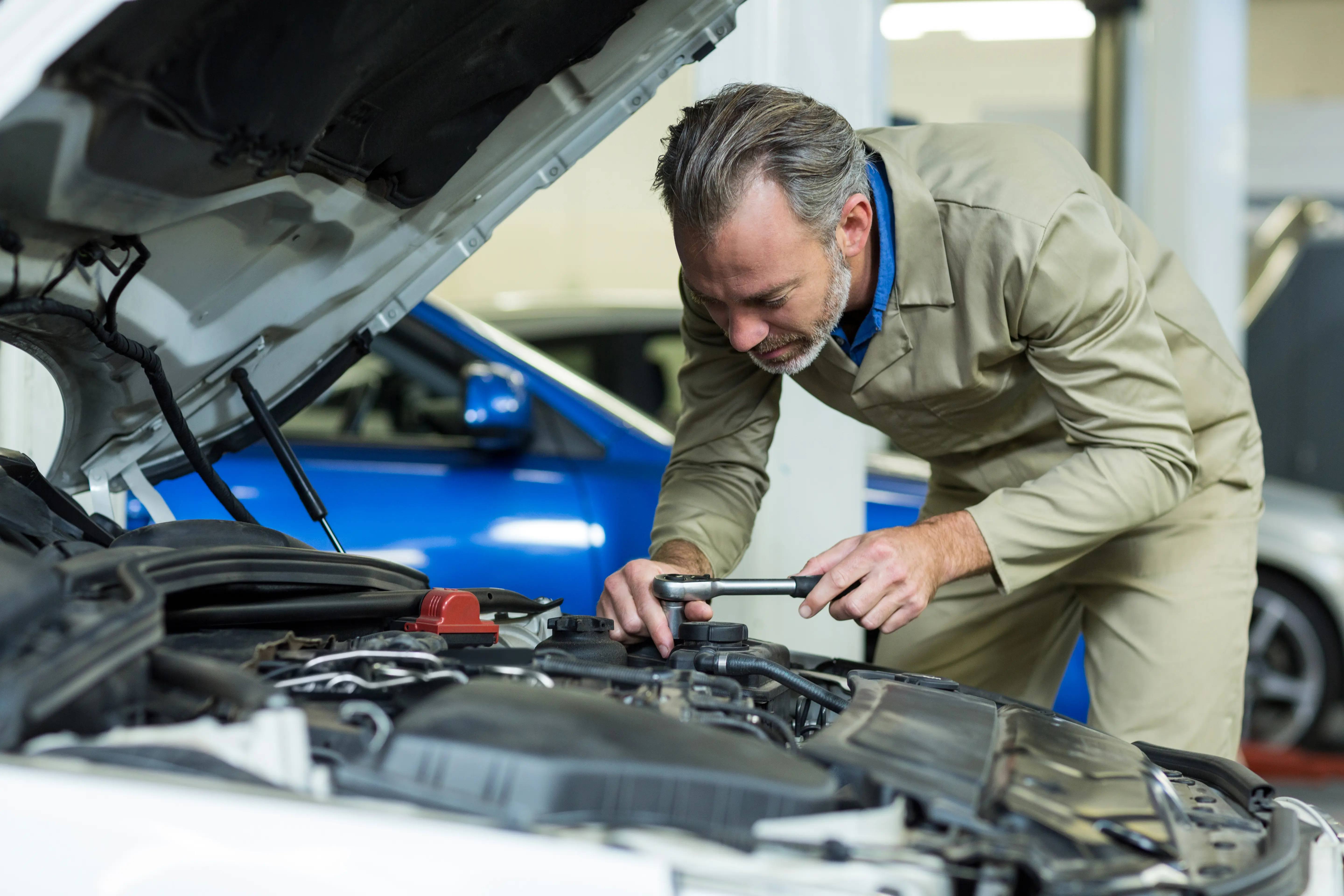 Mechanic repairing car engine.
