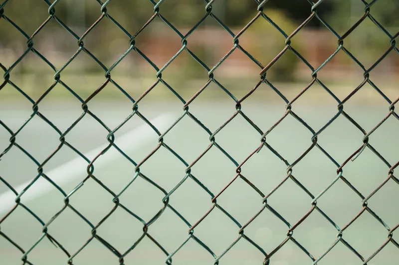 A fence in front of a playground.