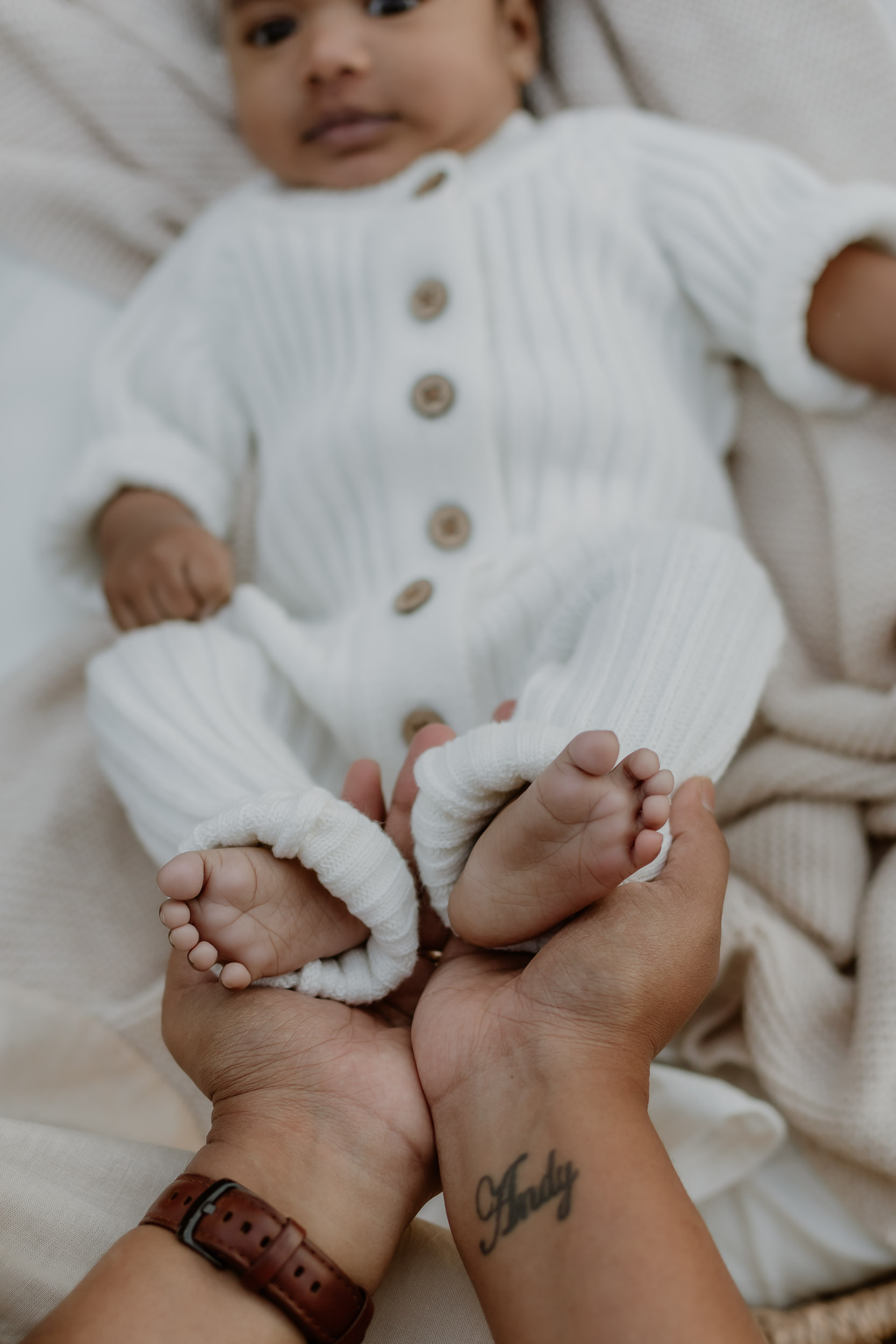 Mother holding baby's feet in newborn photo session in Mackay