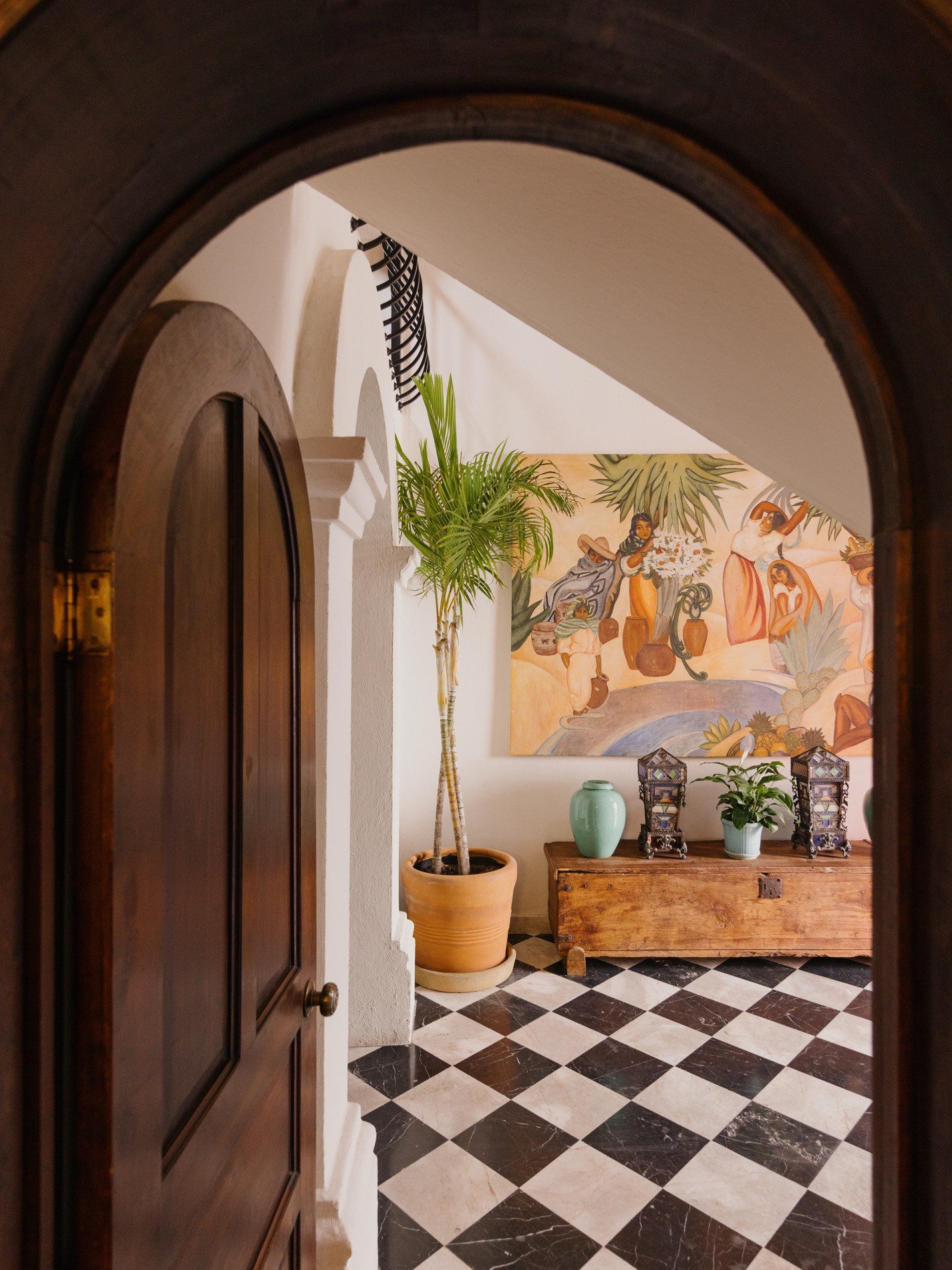 La Residencia San Miguel arched entrance foyer with Mexican mural, checkered marble floor, and ceramics