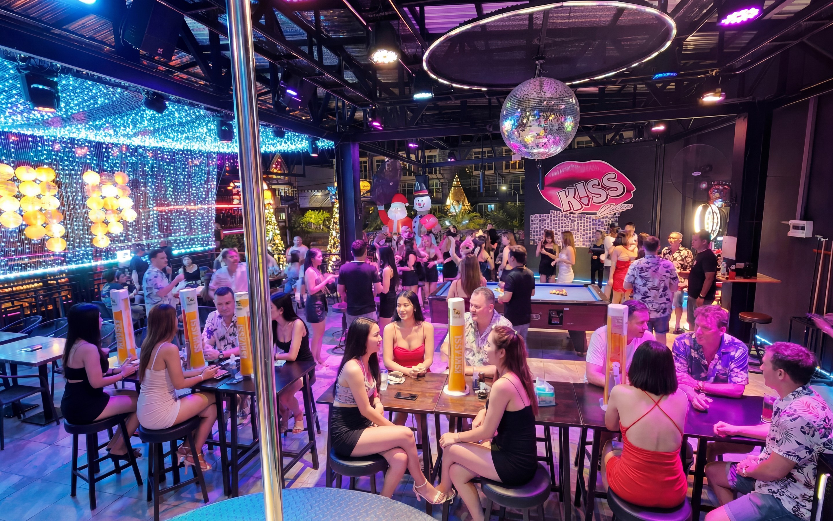 Indoor nightlife venue in Ao Nang with groups socialising, colourful lighting, and tables filled with drinks.
