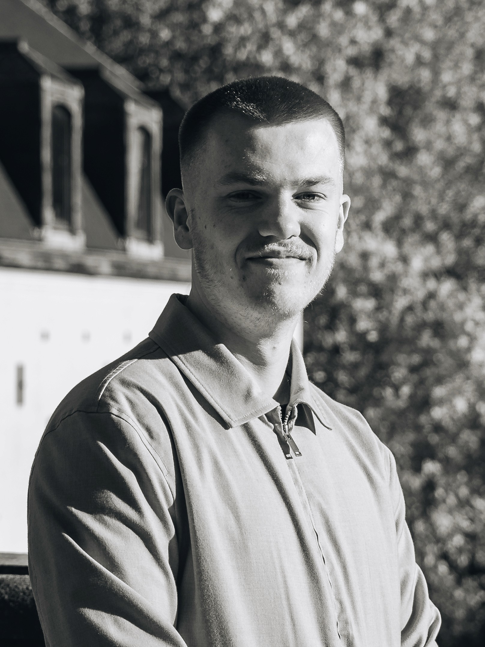 Portrait of a laughing person with curly hair wearing a white shirt