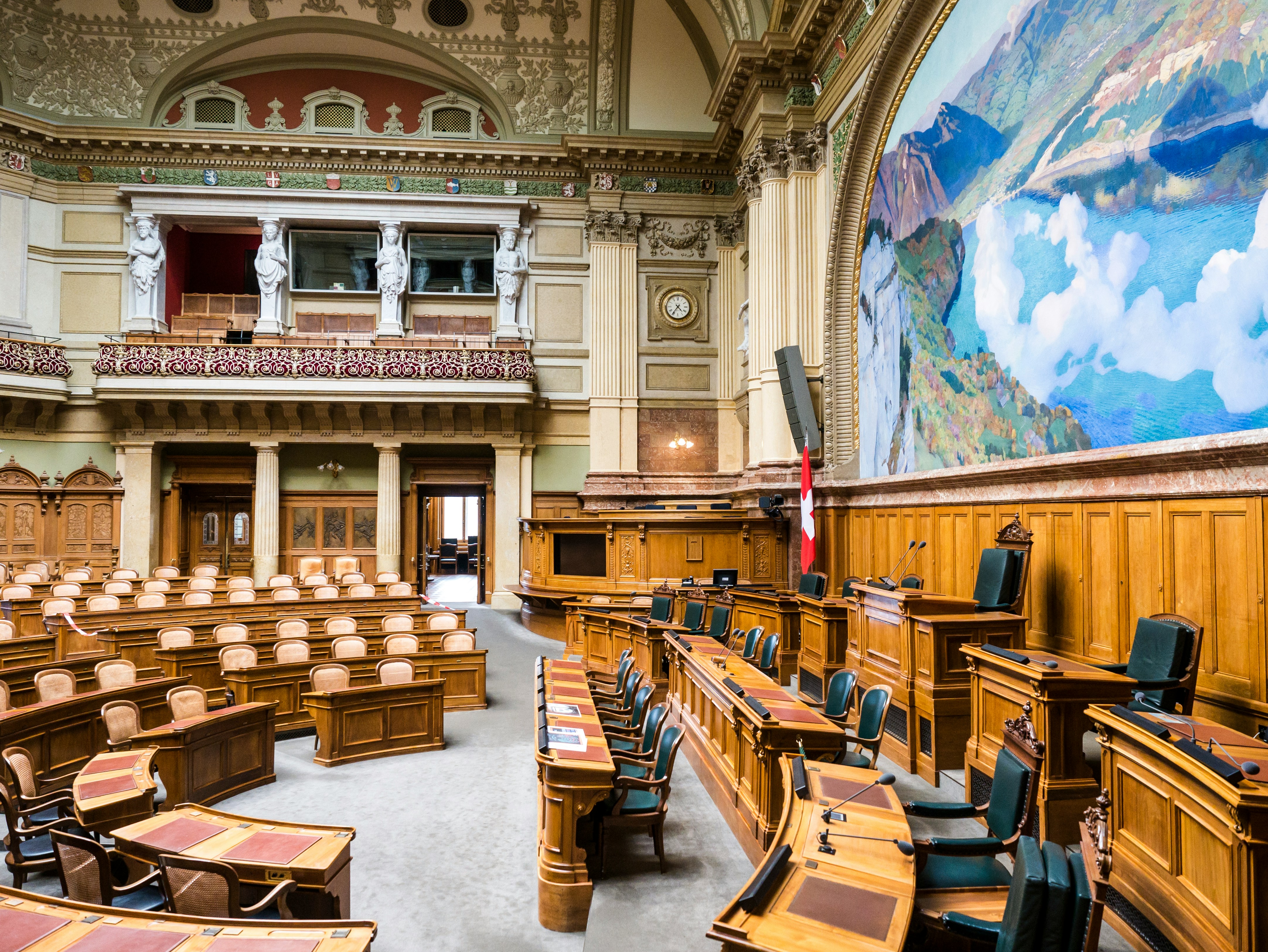 Intérieur de l'Assemblée fédérale suisse, où les décideurs discutent et légifèrent sur des questions telles que la mobilité durable, les politiques d'électromobilité et les réglementations environnementales en Suisse.