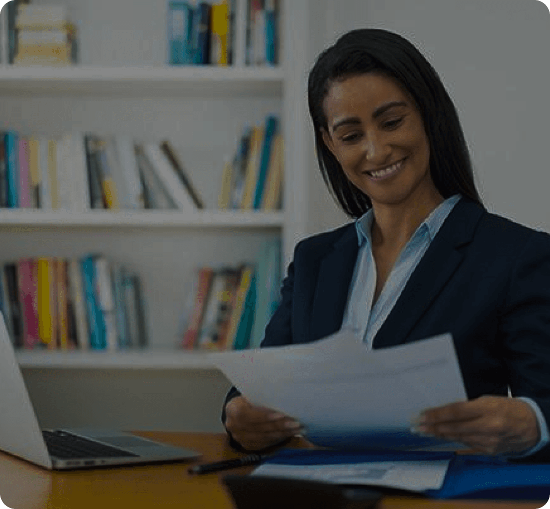 Black woman smiling while looking at a paper