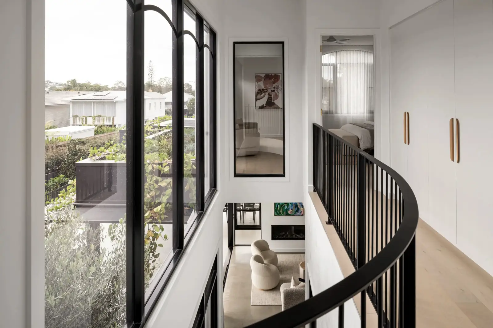 Curved black balustrade and oversized windows that allow natural light in
