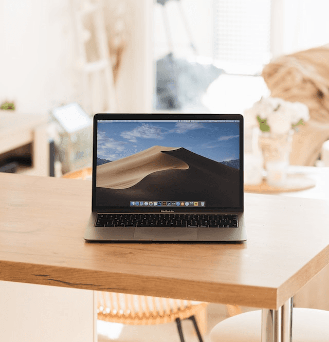 Laptop on a wooden table with a home interior background