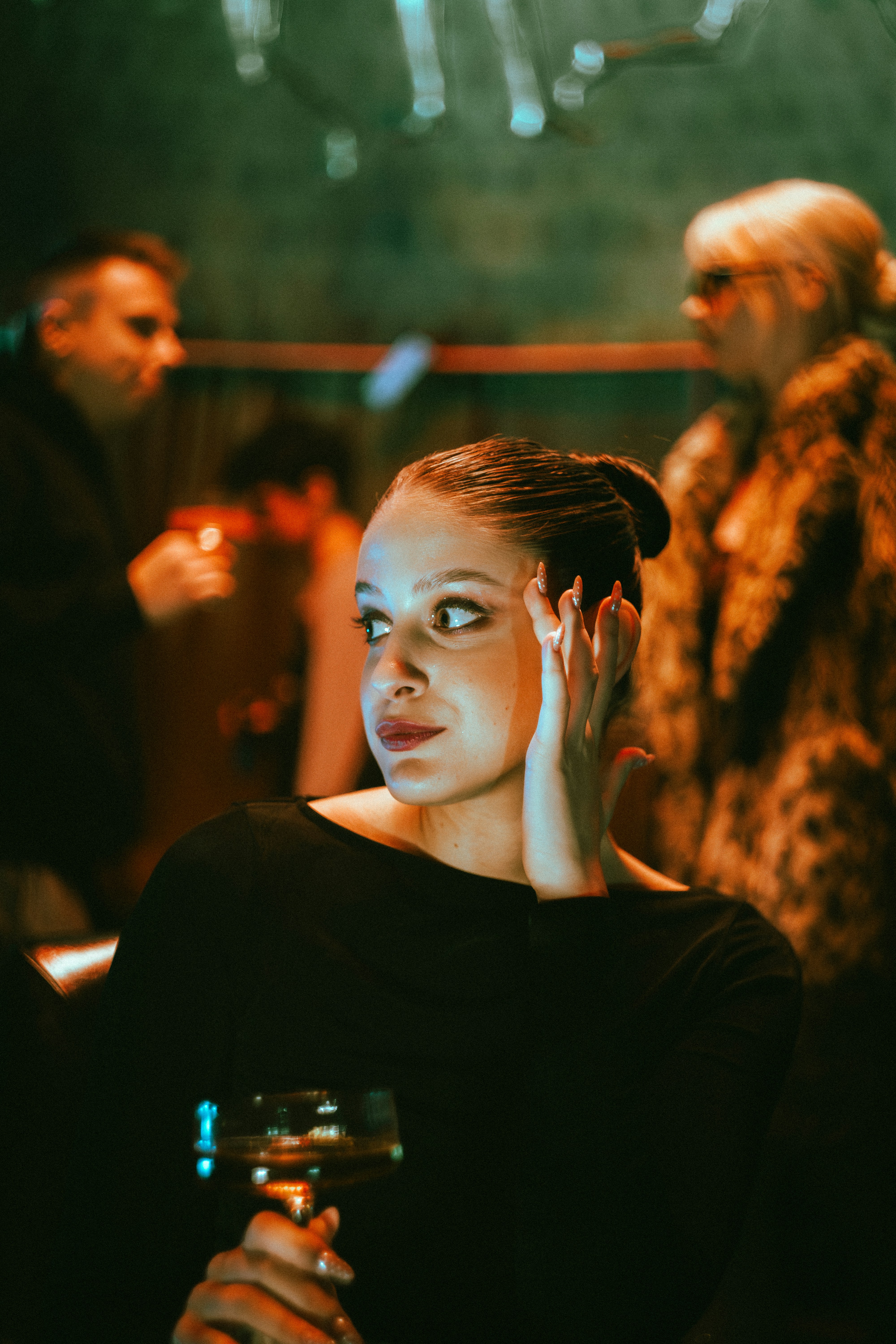 Woman holding a drink at a dimly lit party