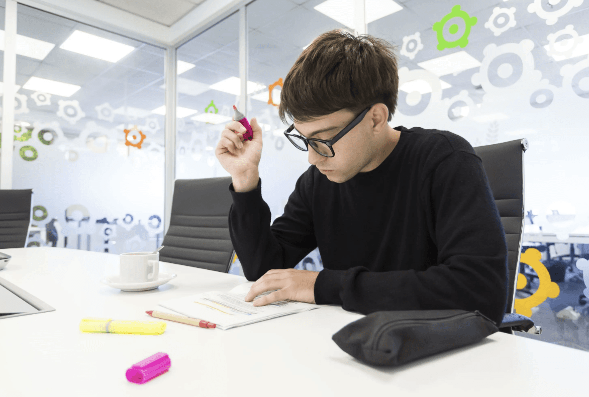 person in gray hoodie holding red and white box