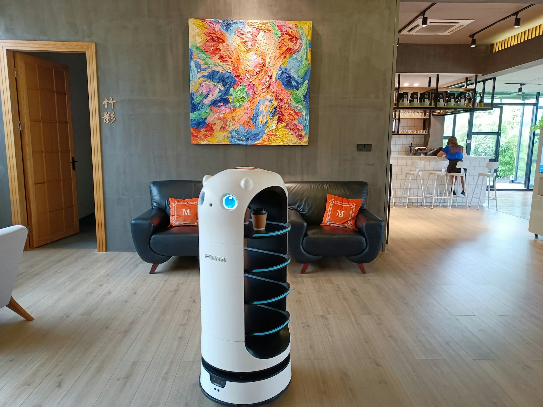Robot de livraison autonome blanc dans un intérieur hôtelier contemporain