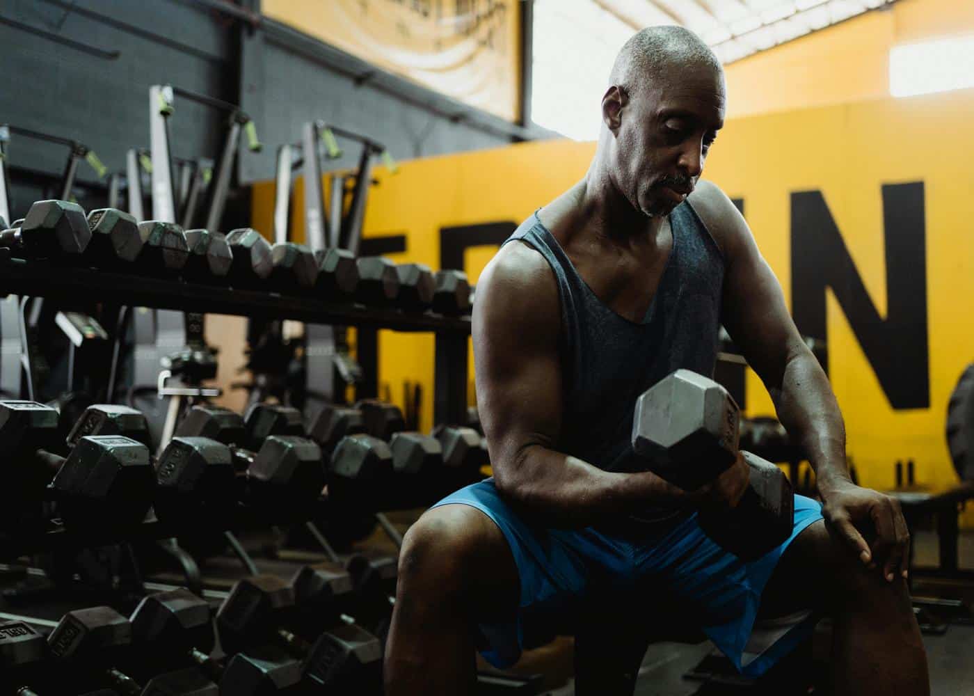 WHOOP Metrics explained: Man working out in a gym with dumbbells