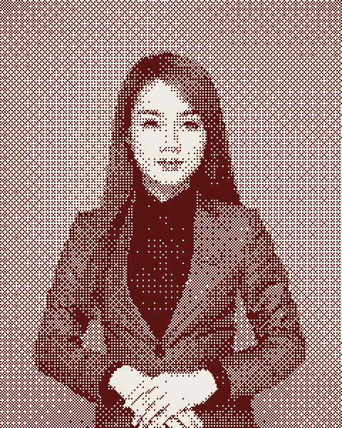 A woman in a grey blazer and black shirt against a grey background
