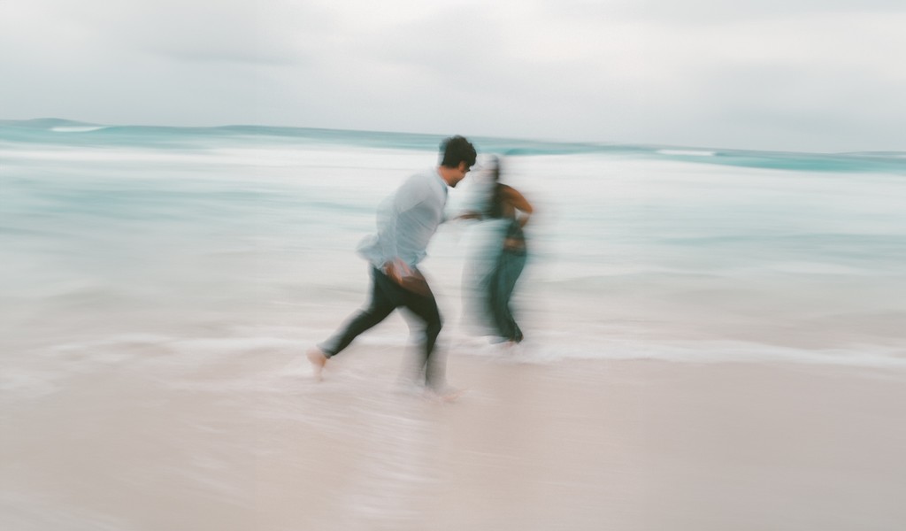 Couple embracing and drying off with a towel after swimming, surrounded by small trees in the jungle at Nômade Tulum, Mexico.