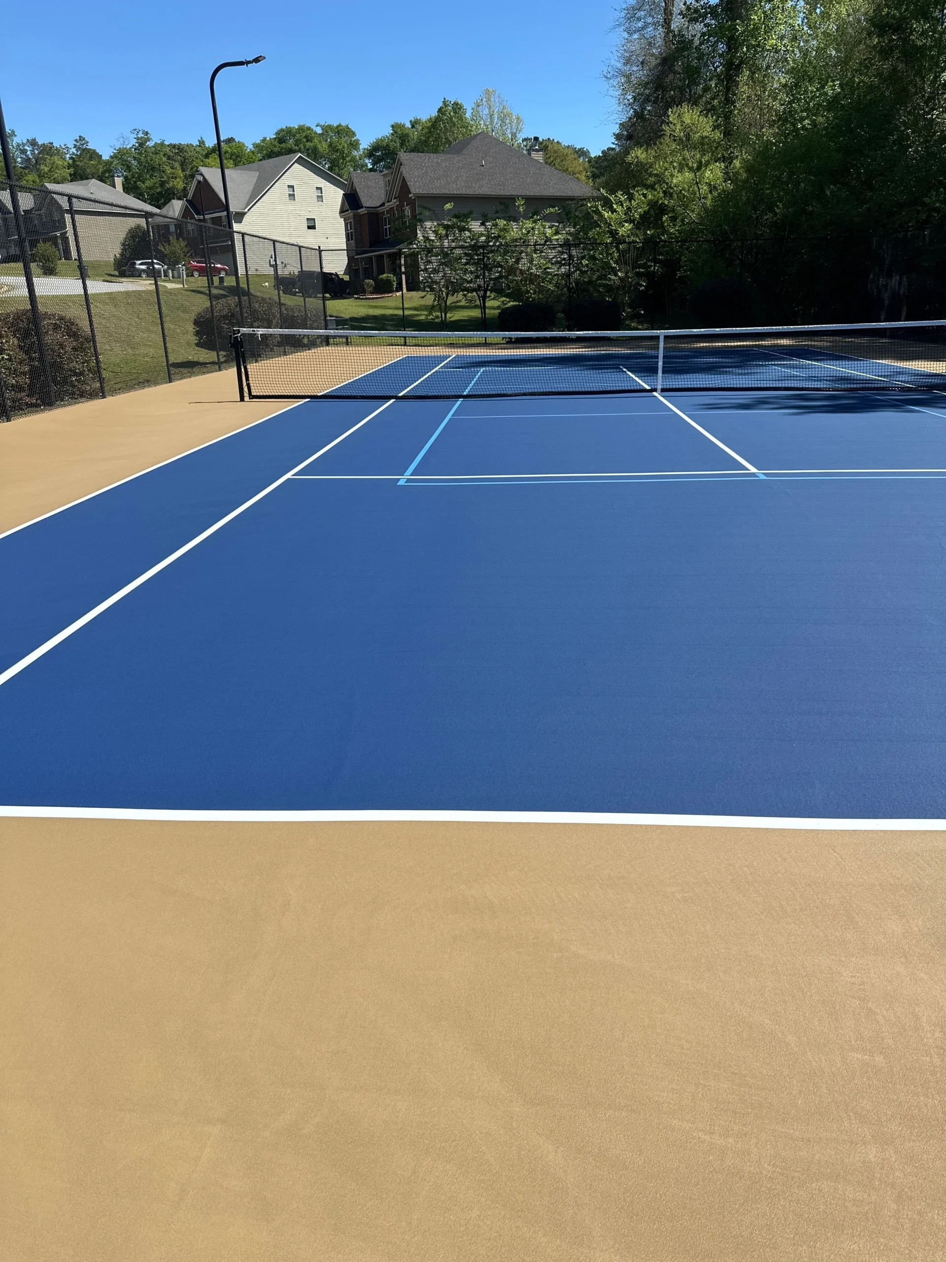 Resurfaced Stadium Blue tennis court with white and light blue pickleball lines in Fort Mitchell, AL HOA community