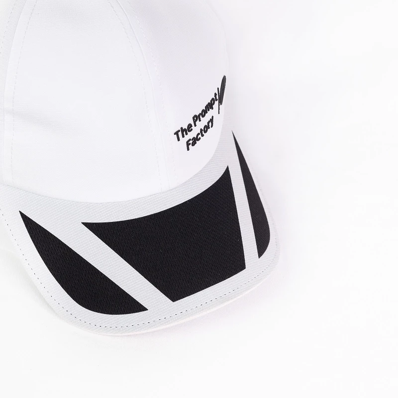 Une casquette blanche de la marque The Prompt Factory photographiée en packshot sur fond clair.