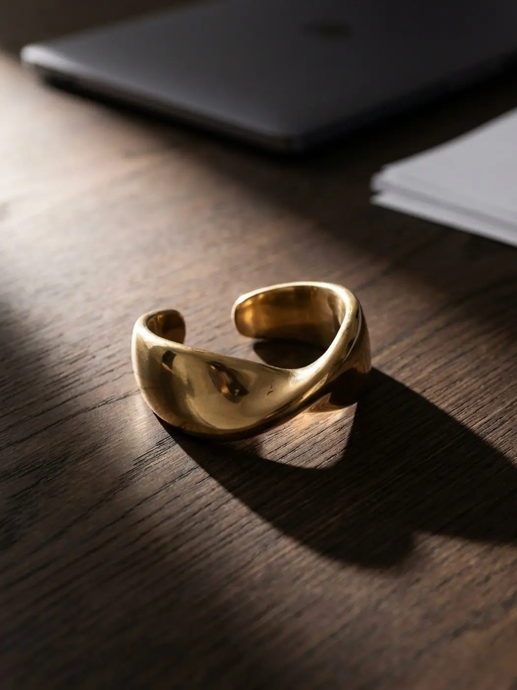 Gold cuff bracelet on a wooden surface