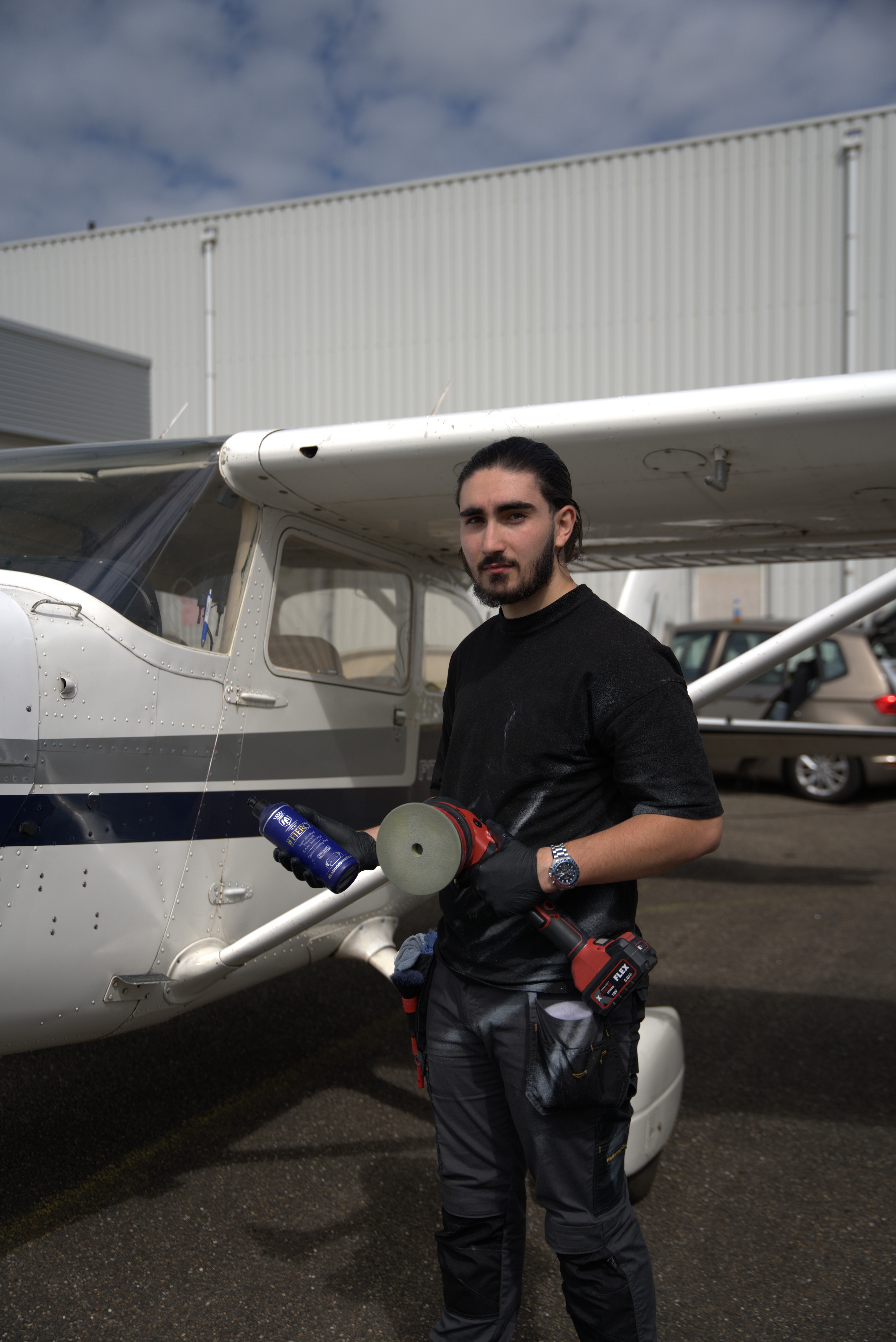 Detailer met polijstmachine voert professionele polijstdiensten uit aan een klein sportvliegtuig.