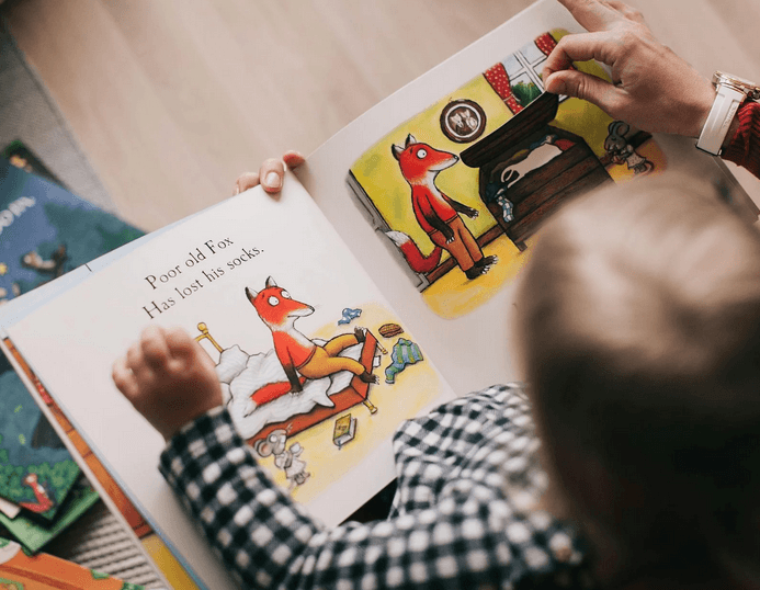 a man and a woman looking at a book on a table