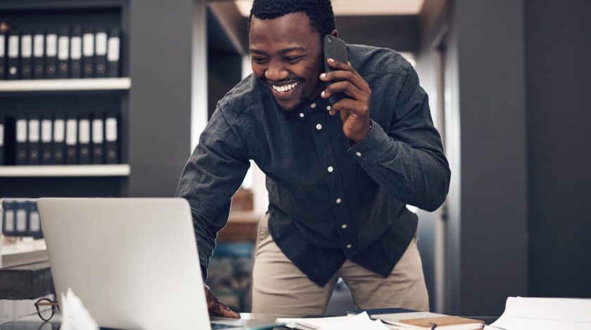 A sleek workspace featuring a laptop, tablet, and smartphone placed on a wooden desk, highlighting modern technology and connectivity.