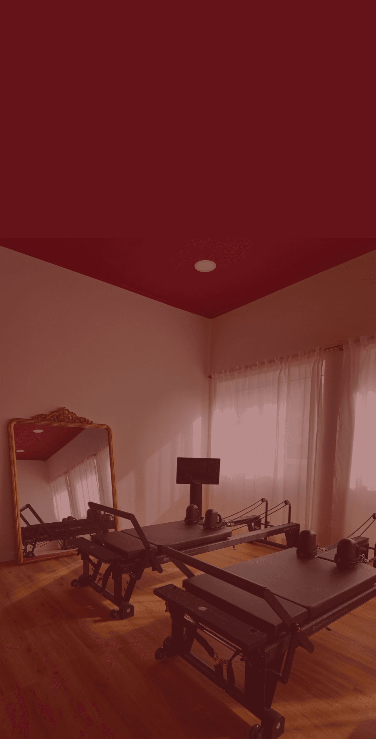 Three women doing an exercise on a reformer machine. 