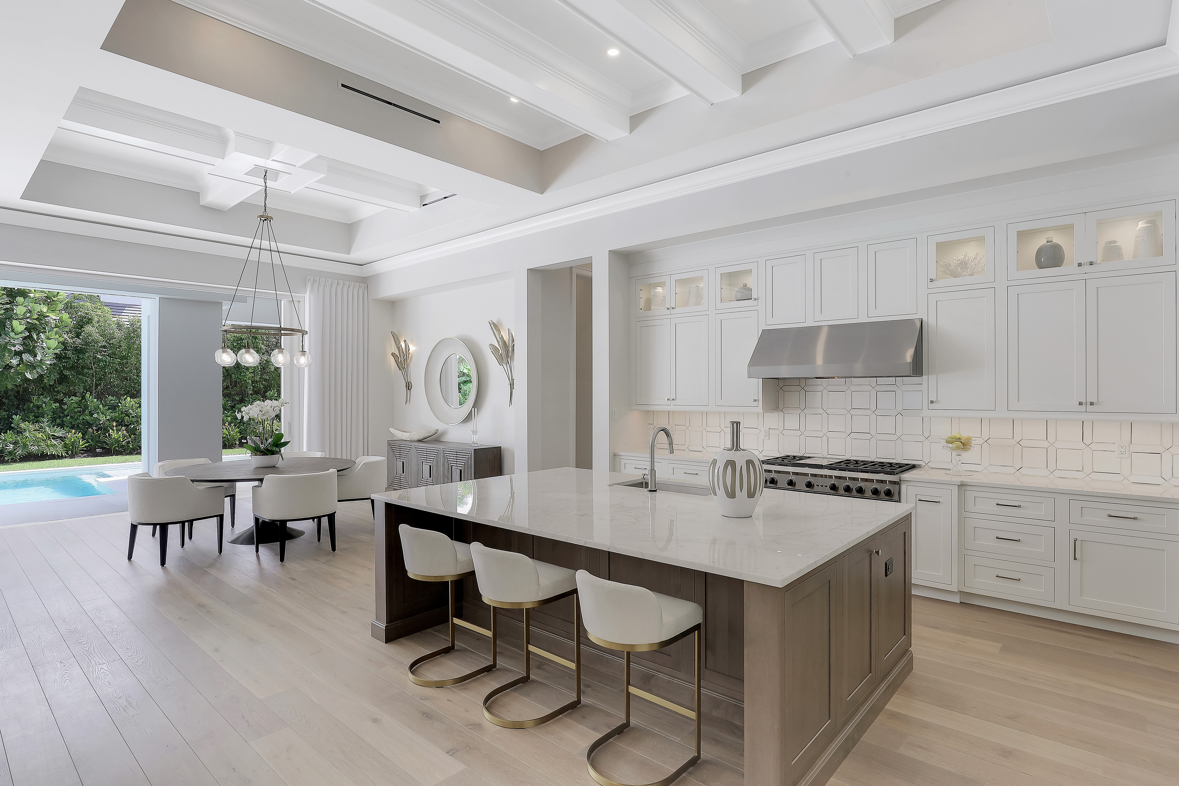 a large modern kitchen with white cabinets, white countertops, and an inset ceiling