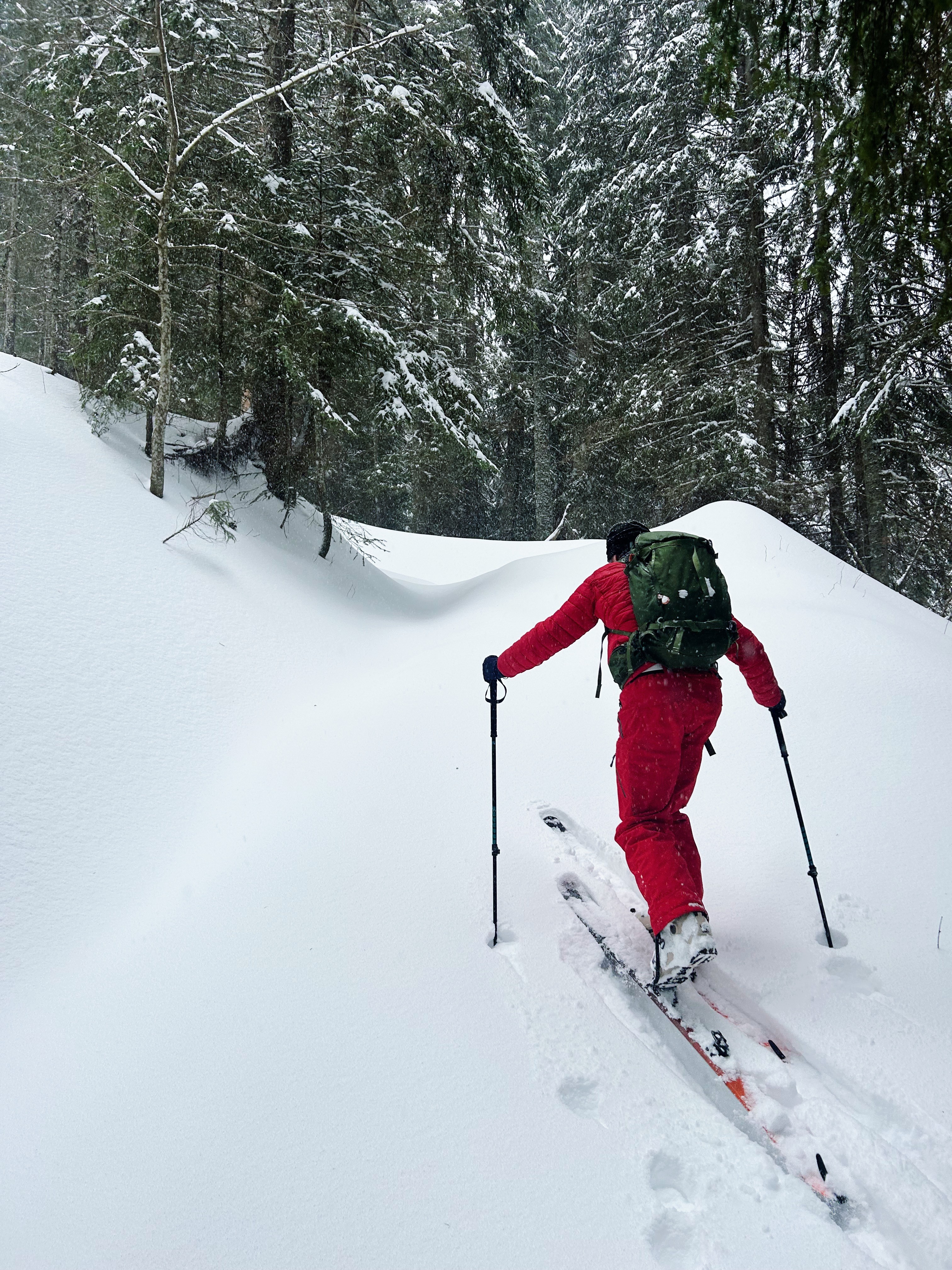 Mountain guide Cristophe ploughs through deep snow in his ski touring gear.