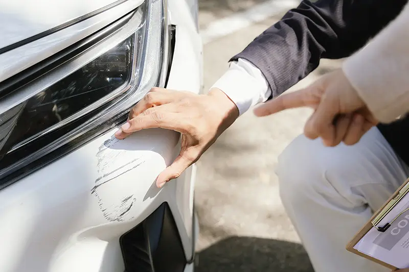 Person inspecting a vehicle interior as part of an auto repair estimate process.