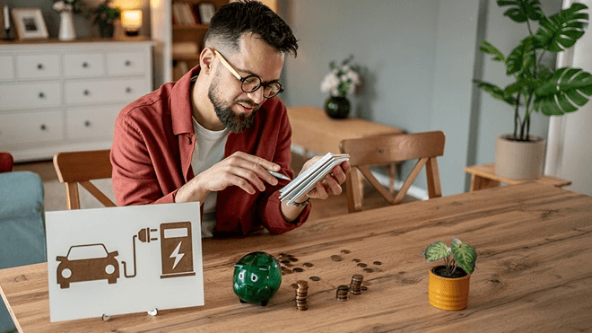 man in orange and black vest wearing white helmet holding yellow and black power tool