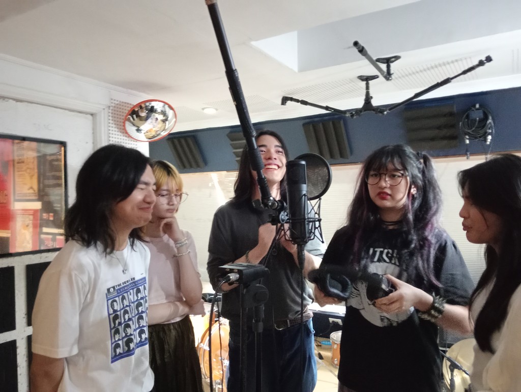 A photo of Abot Tala members inside a recording booth.