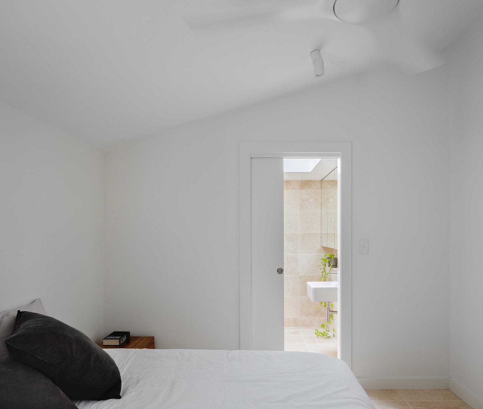 Minimal bedroom inside the Woollahra Treehouse, with white walls, soft natural light, and a quiet connection to the adjacent garden.