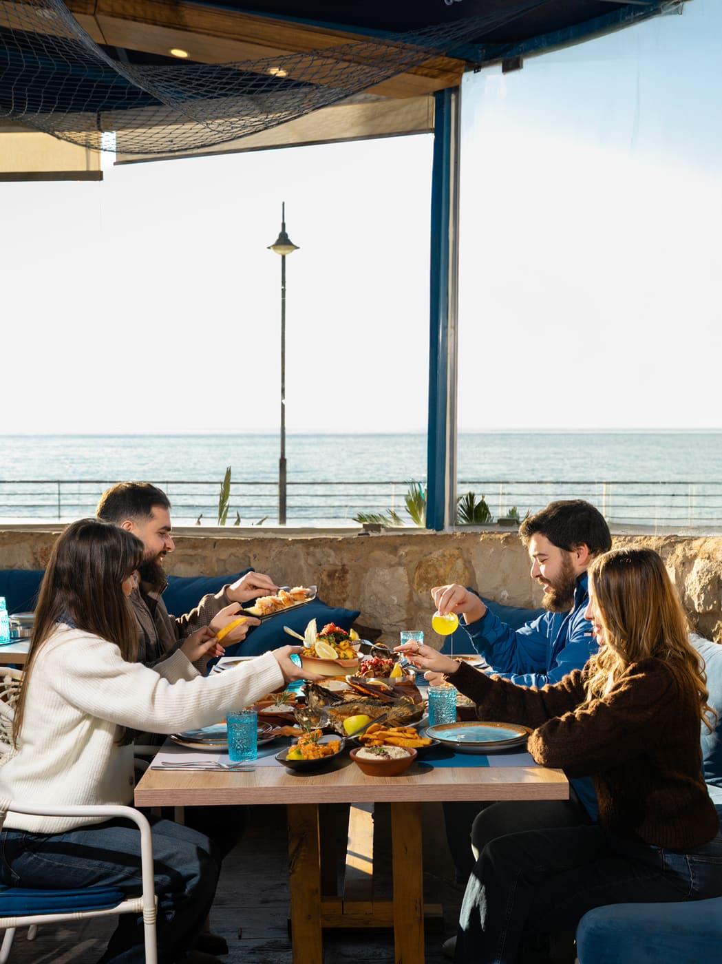 Captain seafood restaurant — guests dining beside the sea-facing windows