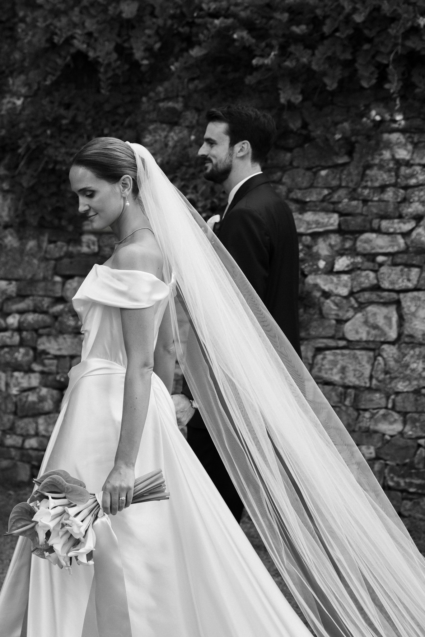 Sposa in abito bianco con velo lungo accanto allo sposo al Castello di Scipione, ritratto di matrimonio in bianco e nero