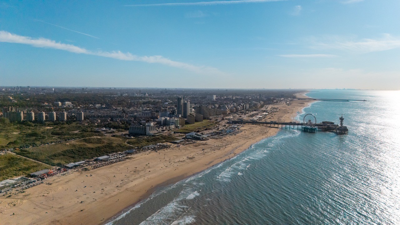 Luchtfoto van het strand en de pier van Scheveningen bij Hotel Four Stories