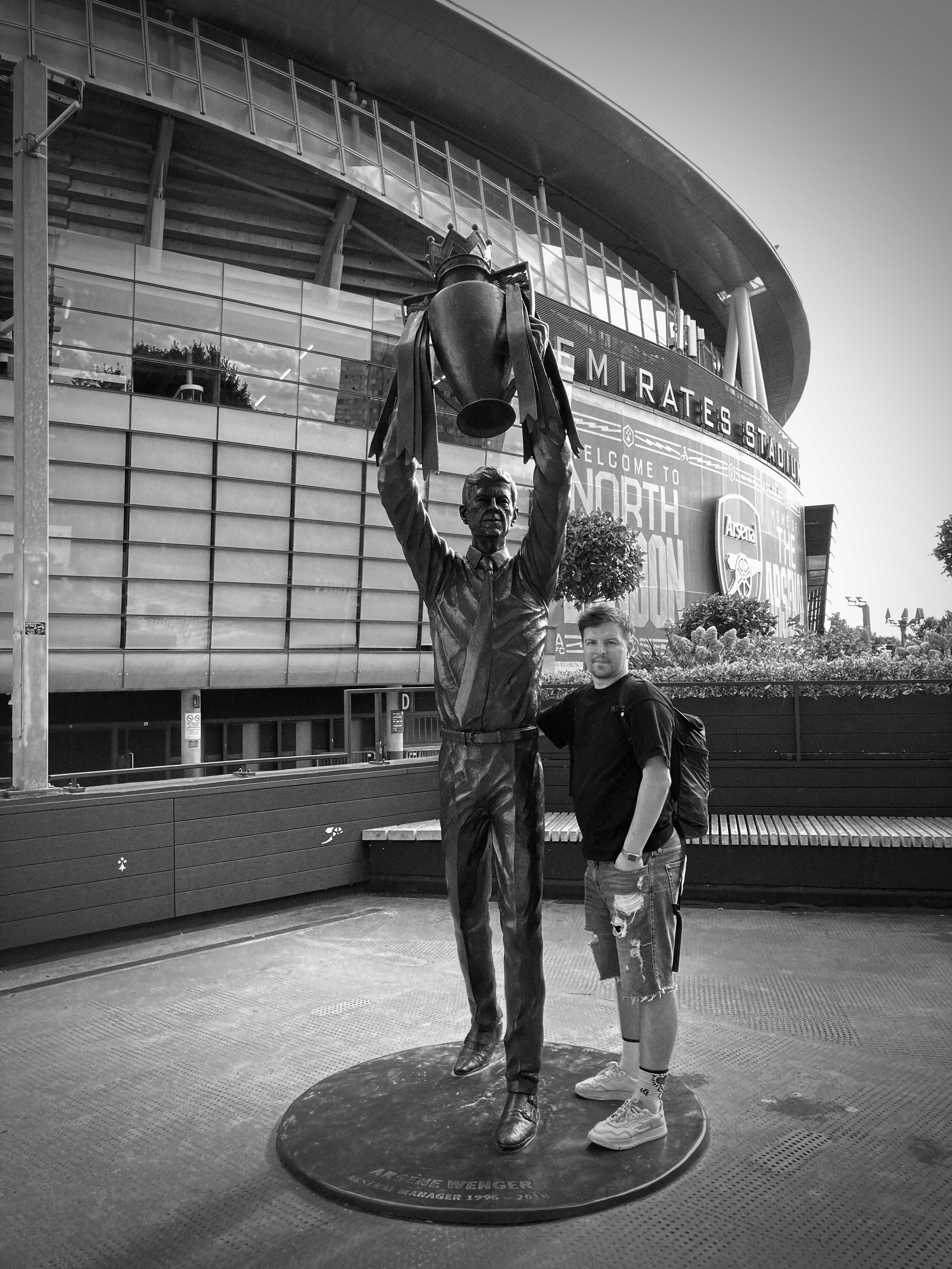 Kamil Zieliński at the Arsène Wenger statue in London, near Arsenal's Emirates Stadium.