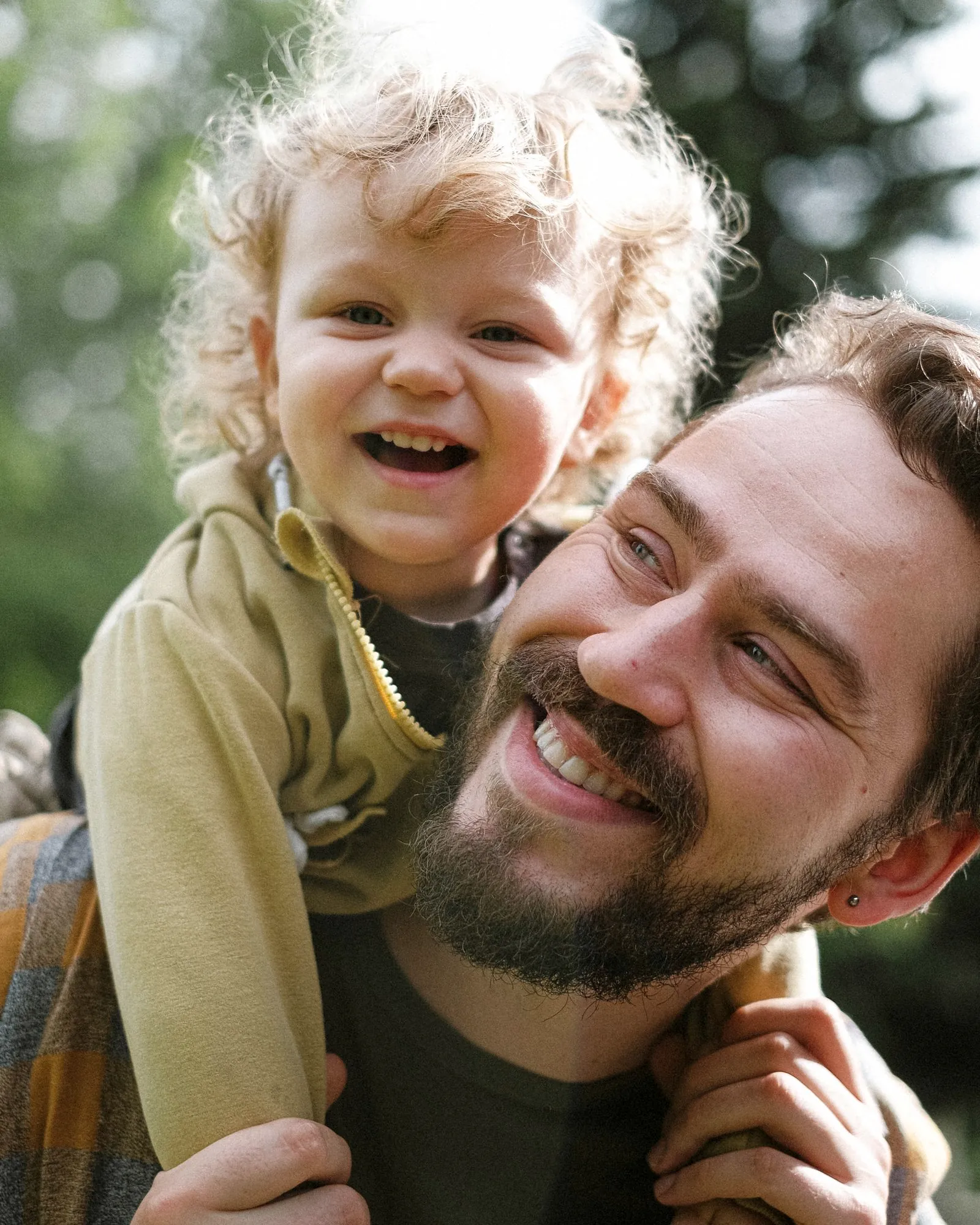 James laughing with his young son on his shoulders