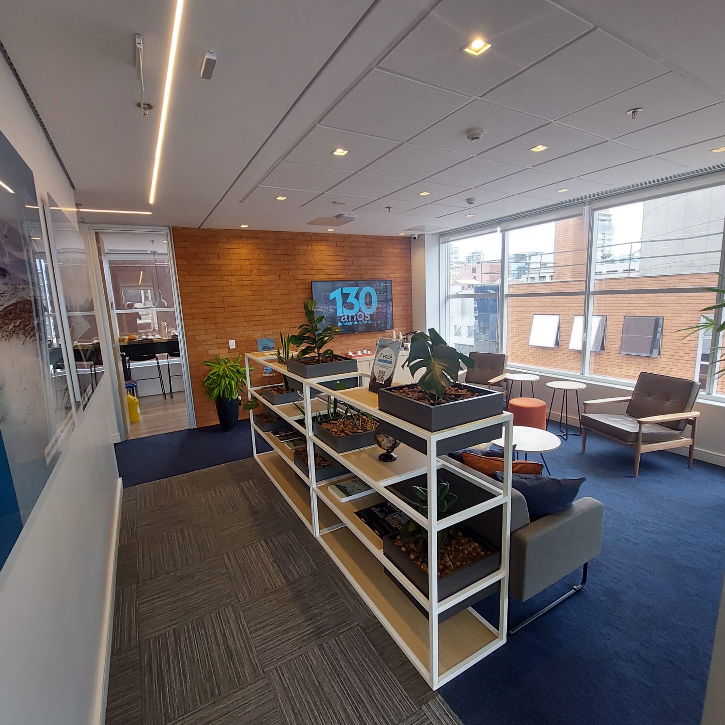 Beige interior with natural stone walls, sunlight, and geometric shadows over a calm water pool.