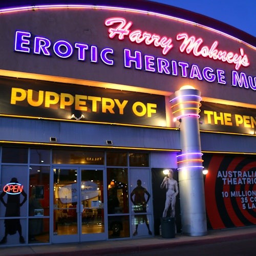 כניסה למוזיאון עם שלטי ניאון הכותבים "מוזיאון המורשת הארוטית של הארי מוהני" ו"תיאטרון של הפין", עם דמויות חלון של ראווה ושלט "פתוח".