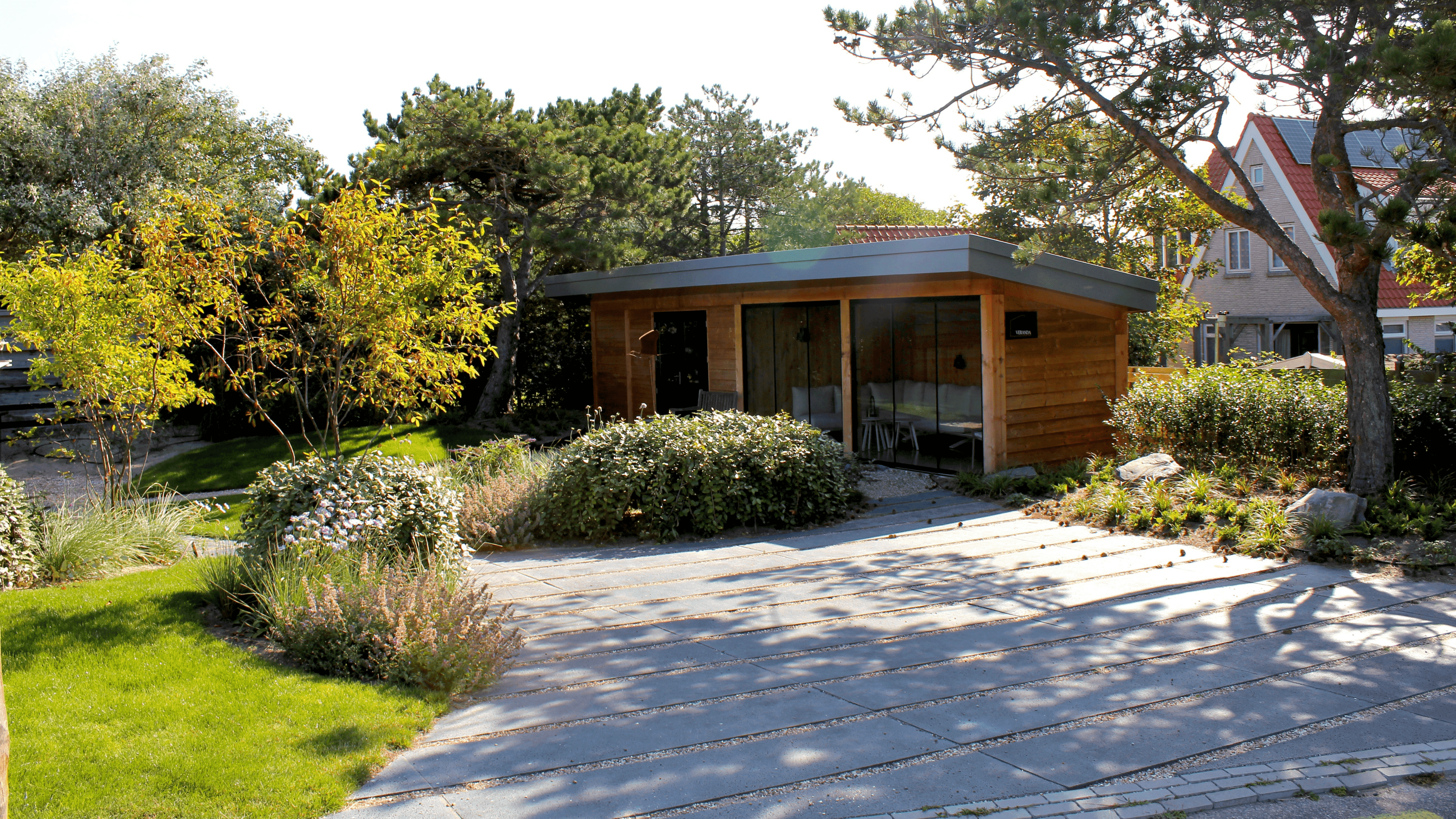 sfeervol tuinontwerp met overkapping en staptegels met beplanting