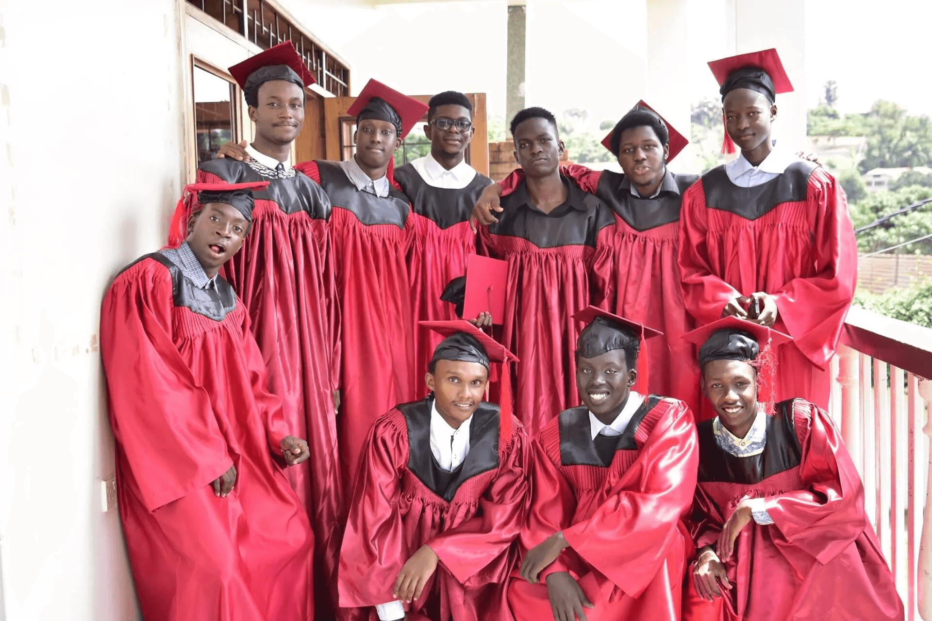 Two schoolgirls holding books are talking near a school building