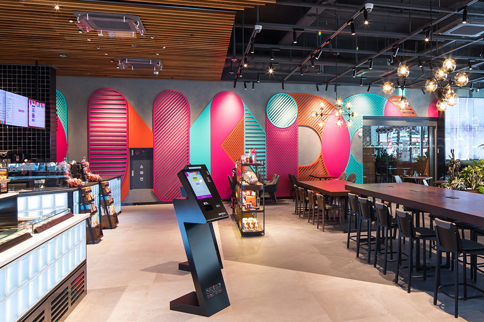 Brightly colored café interior with modern seating, a counter, and artistic wall designs.