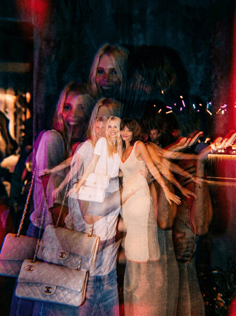 Woman in black outfit sitting on bar stool, leg extended