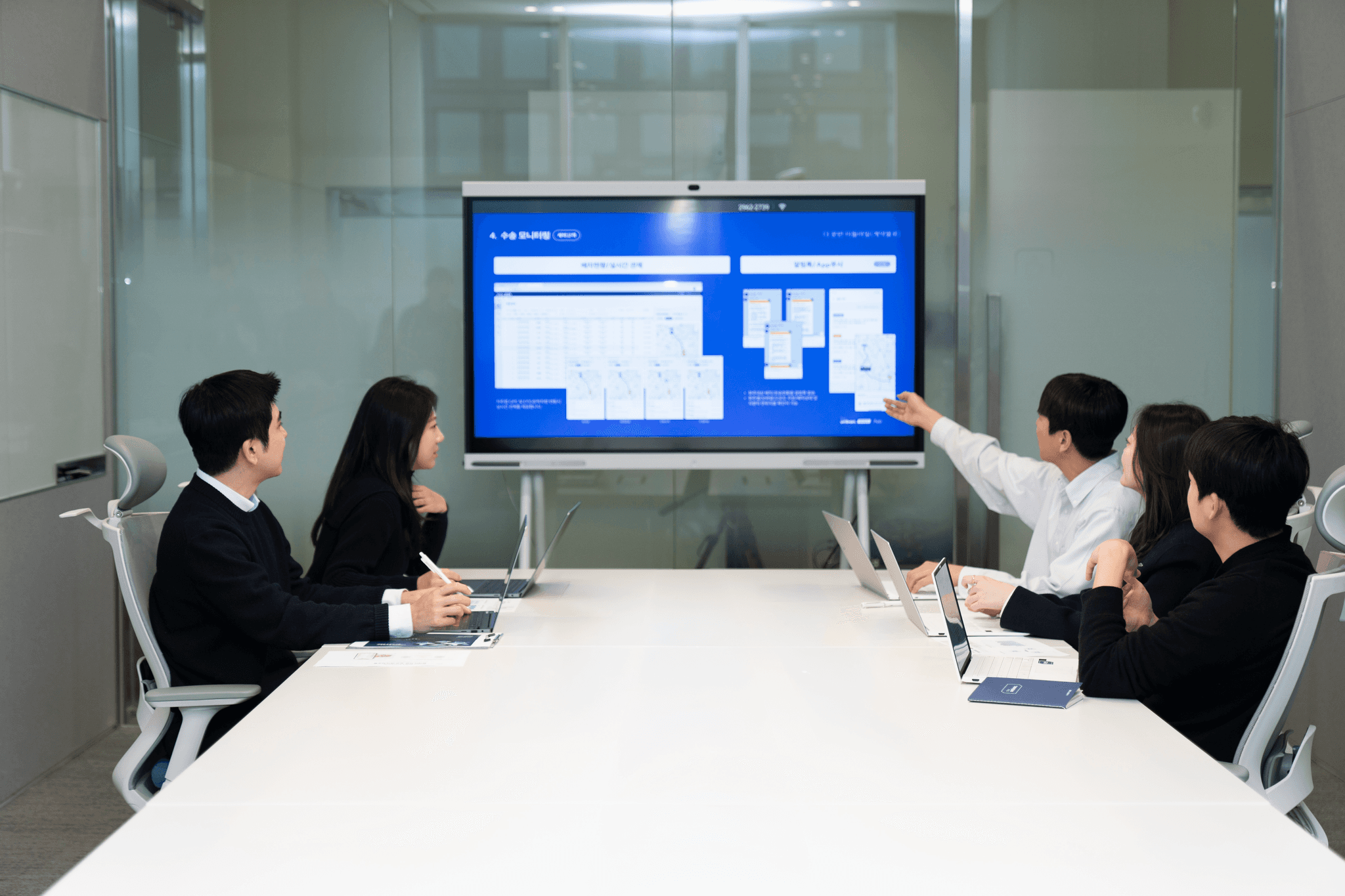 씨제이대한통운 더 운반 담당자들이 회의실에서 운송 운임 협업 방안을 함께 논의하고 있습니다.